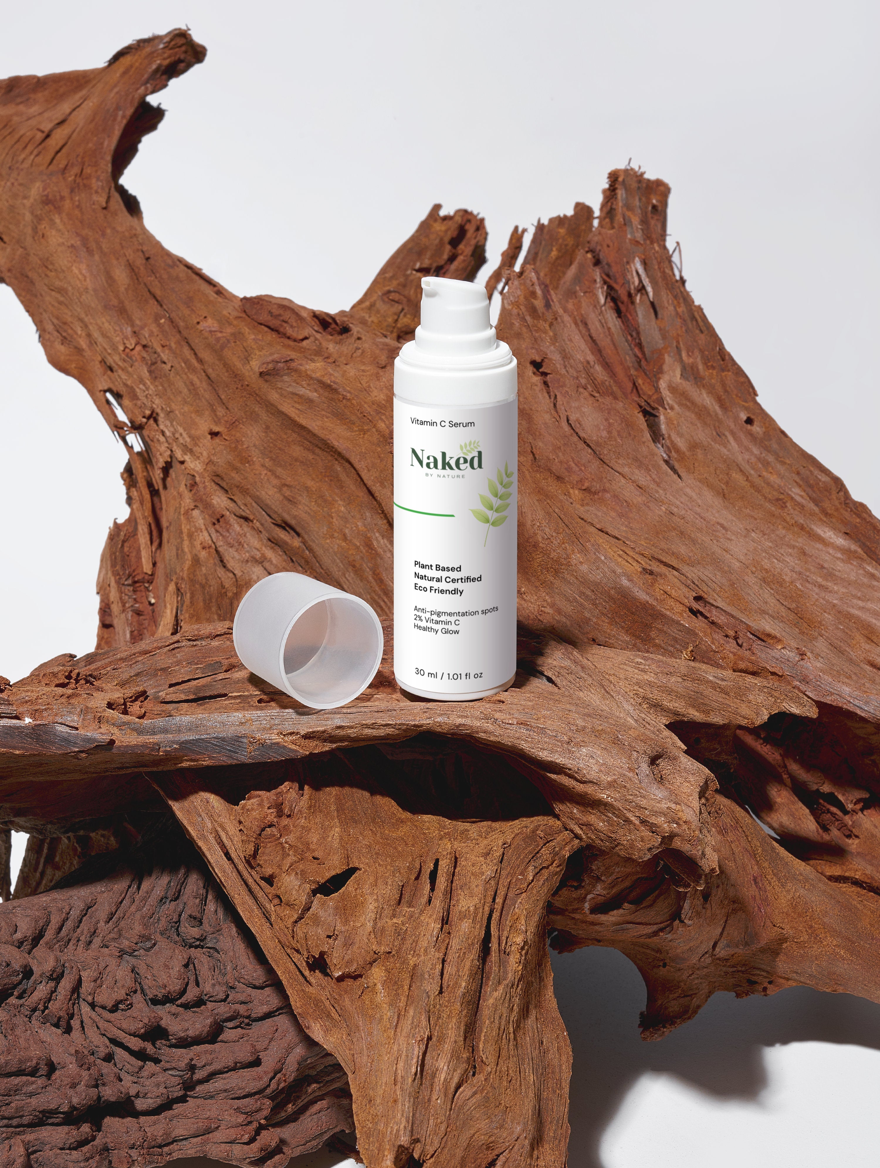 Naked by Nature Vitamin C Serum bottle on rustic wood, plant-based, eco-friendly skincare for healthy glow
