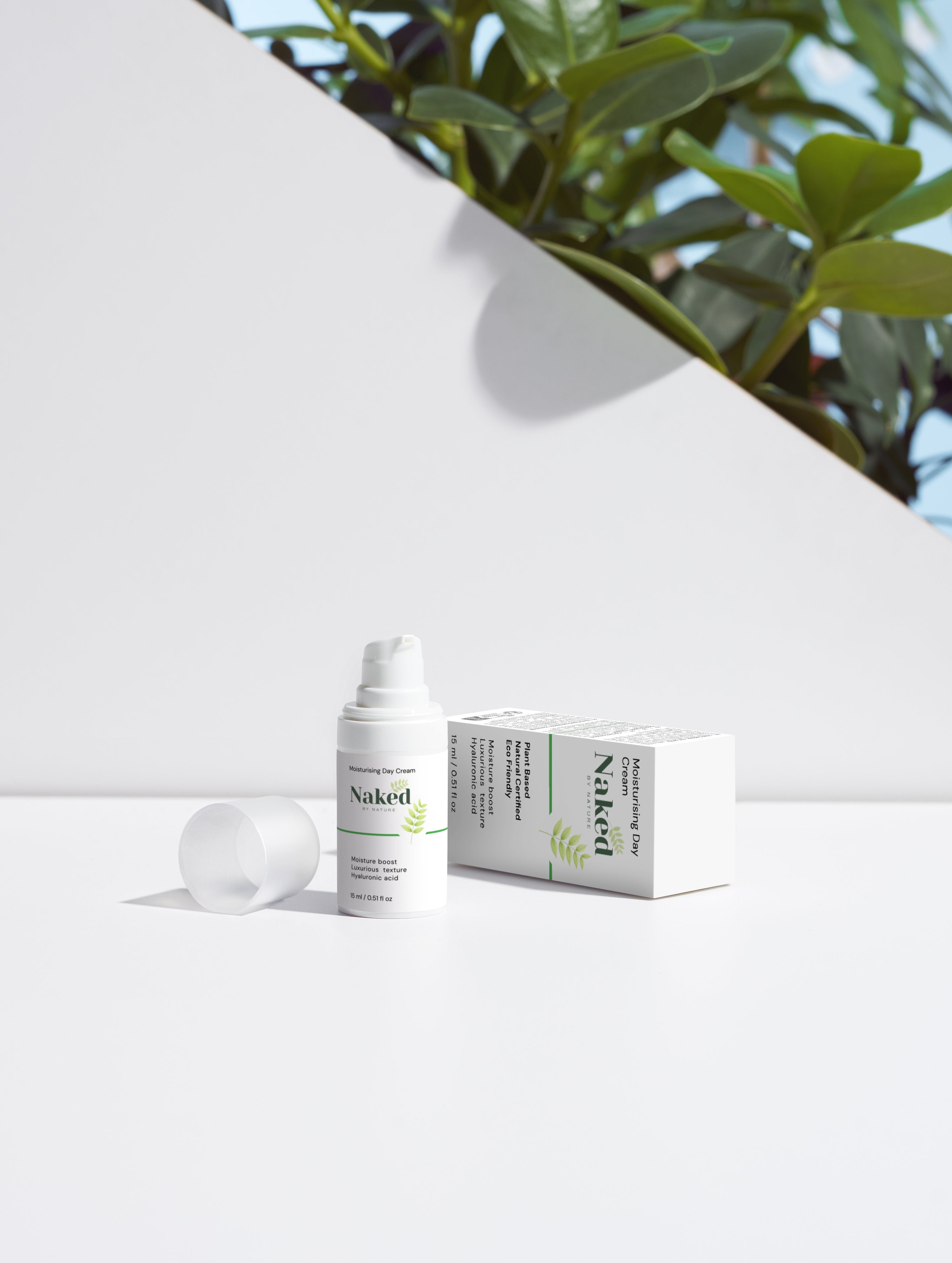 Naked by Nature Moisturising Day Cream with hyaluronic acid, plant-based formula, eco-friendly packaging, beside lush green plant