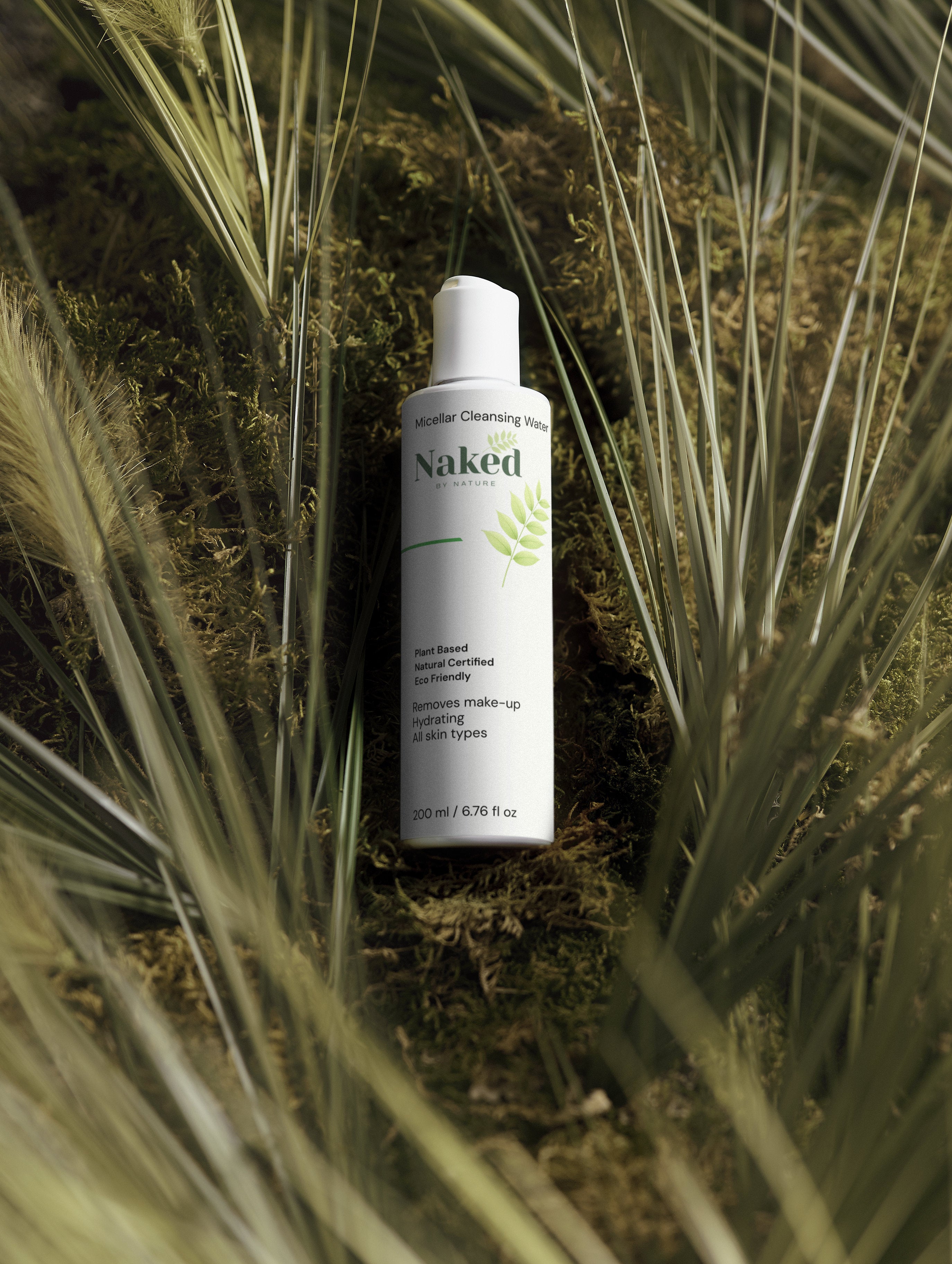 Naked by Nature Micellar Cleansing Water bottle nestled in moss and grass, plant-based, eco-friendly, hydrating for all skin types